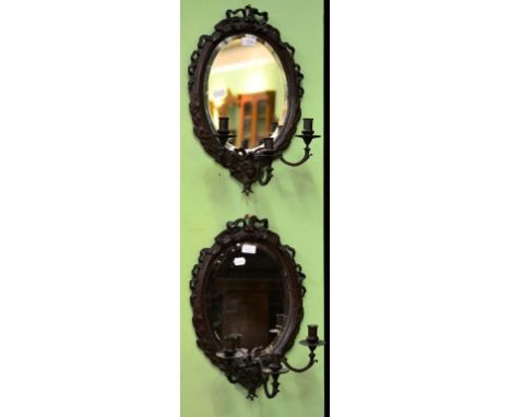 A Pair of Bronzed Three-Light Girandoles, 19th century, the oval plates below ribbon crestings, over scroll branches and mask