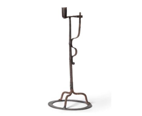 An 18th Century Wrought Iron Rushlight and Candle Holder, with serpentine spring on plain stem and tripod base with circular 