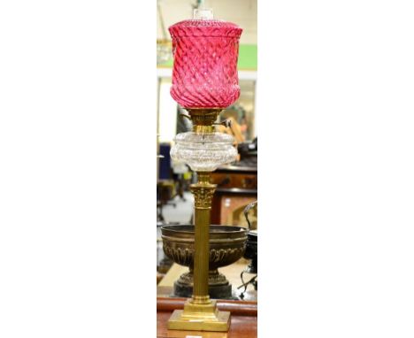 A Brass Corinthian Column Oil Lamp, cranberry wrythen moulded glass shade, cut clear glass reservoir, stepped base, 78cm high