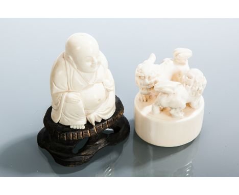 CHINESE IVORY BUDDHA AND A CHINESE IVORY SEAL
the Buddha holding fruit, on a wooden stand, 9cm high, the seal carved in relie