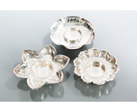 GROUP OF THREE CHINESE SILVER CANDLE STANDS
one formed as a flower head, the other two of shaped circular form, approximately
