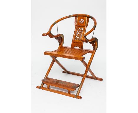 EARLY 20TH CENTURY CHINESE HARDWOOD FOLDING CHAIR 
with central carved back panel, linked slat seat and foot rest, with brass