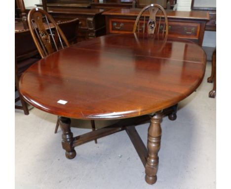 An Ercol style elm dining suite comprising oval extending table and 4 wheel back chairs