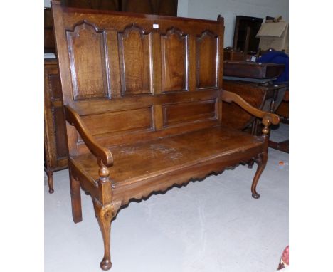 An 18th century oak settle of small proportions, the high panel back with pyramid finials, and 4 fielded ogee arch panels, so