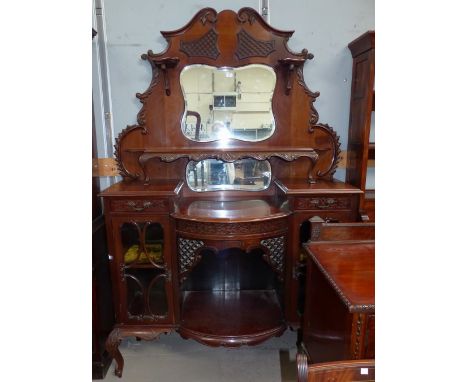 An Edwardian carved mahogany chiffonier, the raised mirror back with shelf, 2 glazed cupboards and central open shelf below