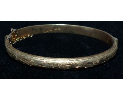 A 9 carat hallmarked gold bangle with chased decoration, 8.4 gm