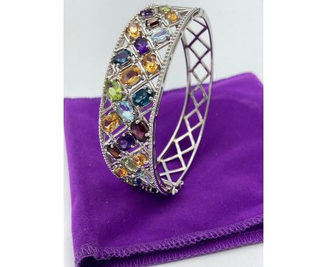 Silver multi gemstone bracelet/bangle having amethyst,aqua,peridot,topaz, etc set in silver lattice framework. Full UK hallma