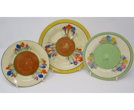Two Clarice Cliff Bizarre plates in the Crocus pattern, together with a Clarice Cliff for Newport pottery plate in the Spring