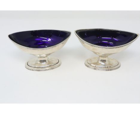 Pair of Georgian hallmarked silver open salts with blue glass liners, London assay, L: 11 cm, 134g. P&amp;P Group 2 (£18+VAT 