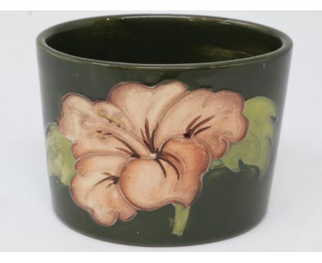 Moorcroft oval vase in the Hibiscus pattern against a green ground, H: 60 mm, surface wear and crazing throughout. P&amp;P Gr