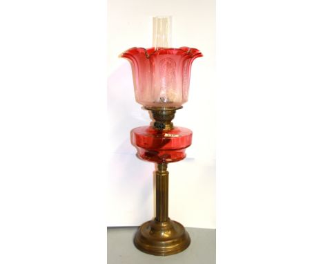 A 19th Century brass and cranberry glass oil lamp, H. 59cm.
