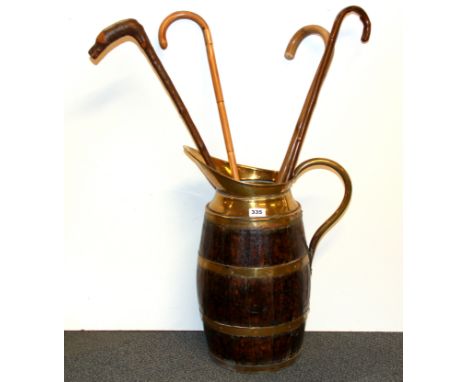 An oak and brass barrel stick stand, H. 54cm together with four walking sticks.