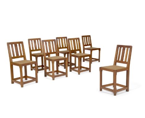 A SET OF SEVEN ARTS & CRAFTS OAK SIDE CHAIRS  CIRCA 1910, IN THE MANNER OF ROBERT THOMPSON Each with a check covered seat  86