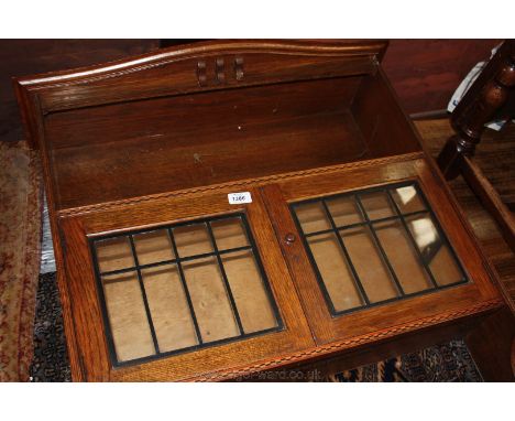 An Edwardian Oak wall mounted Cupboard, bow fronted top with corbel supports, single shelf over pair of opposing eight pane l