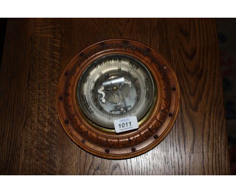 A Barometer with circular carved surround.
