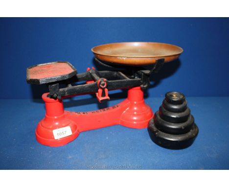 A red painted Kitchen Scales up to 14lbs and five weights.