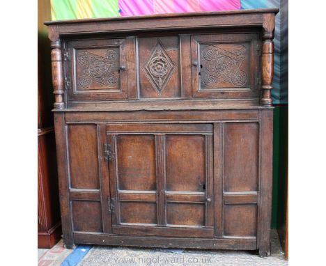 A circa 1800 Oak Cwpwrdd Deuddarn, having plank top on heavy turned supports, the top section having central diamond carved p