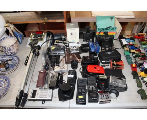 A collection of various cameras to include Minolta, Pentax, various accessories including tripod stand etc.