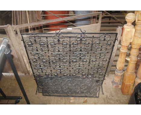 An ornate wrought metal, three fold fire screen