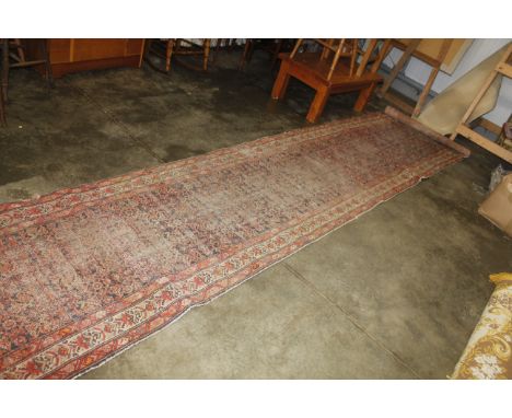 An approx. 16'8" x 3'3" red patterned runner AF