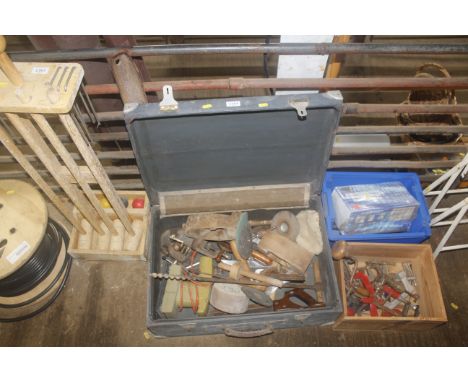 A wooden chest with hinged lid and contents of various tools to include small bench vice, wooden smoothing planes, grinding d