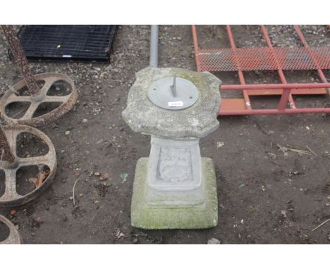 A small sundial sat upon cast concrete plinth