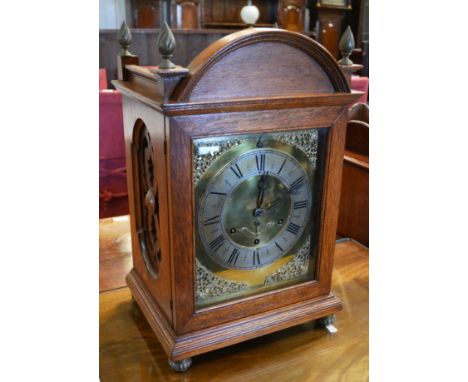 Late Victorian oak mantel clock, brass face, silvered chapter ring, cast spandrels, musical movement, striking on eight bells