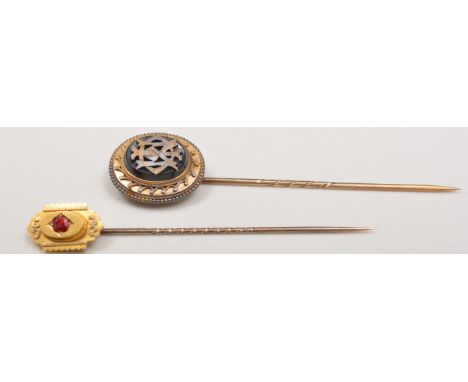 Victorian 15ct gold stick pin, set with a ruby and a gilt metal and black onyx stick pin (2).