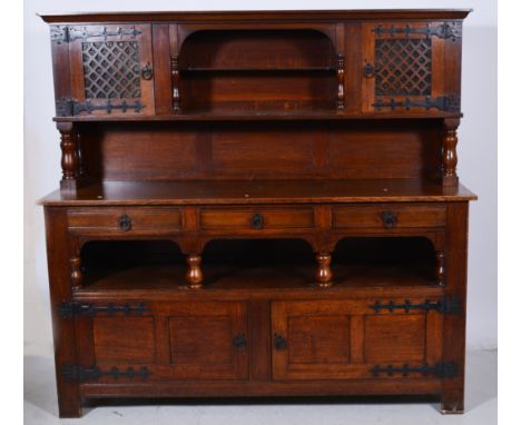 Oak sideboard, raised back with an open arch incorporating a shelf, flanked by fret panelled doors, backed by glass, base sec