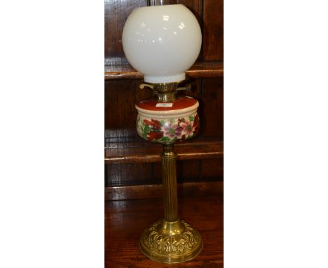 Brass oil lamp, opaque and painted reservoir with shade and chimney, 73cm overall.