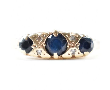 A hallmarked 9ct gold sapphire and diamond three stone ring. The ring having a central round cut sapphire flanked by two diam