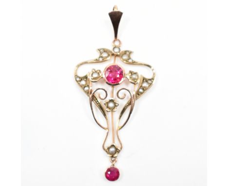 An early 20th Century Edwardian Art Nouveau 9ct gold, ruby and seed pearl pendant. The pendant of whiplash form with a bezel 