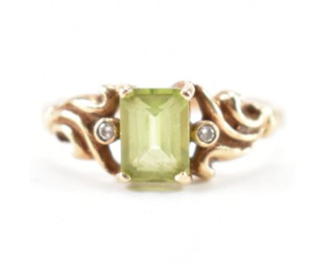 A hallmarked 9ct gold peridot and diamond ring. The ring being set with a step cut peridot flanked by diamond accent stones i