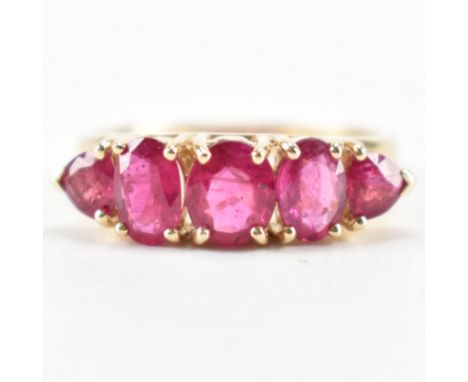 A hallmarked 14ct gold and synthetic ruby ring. The ring being set with three oval cut synthetic rubies and two trilliant cut