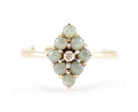 A gold green stone and diamond cluster ring. The ring having a diamond shaped had with a central diamond surrounded by eight 