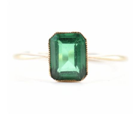 A hallmarked 9ct gold and green stone ring. The ring being set with a emerald cut green stone in a bezel setting. Hallmarked 