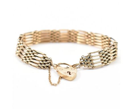 A hallmarked 9ct gold gate link bracelet. The bracelet having a heart padlock on a gate link bracelet. Hallmarked London 1977