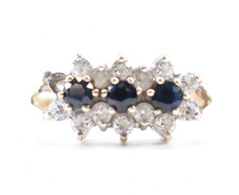 A hallmarked 9ct gold sapphire and cz cluster ring. The ring being set with three round cut sapphires surrounded cy round cut