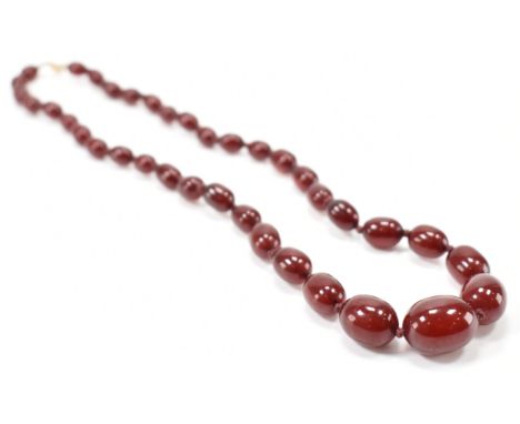 A 1930s art Deco cherry bakelite&nbsp; beaded necklace. The necklace having graduating oval beads with a spring ring clasp. M