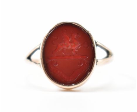 A 19th Century Victorian gold intaglio ring. The ring being set with an oval red stone panel with engraved family crest for t