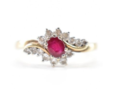 A hallmarked 9ct gold ruby and white stone ring. The ring being set with an oval cut ruby with round cut white accent stones 