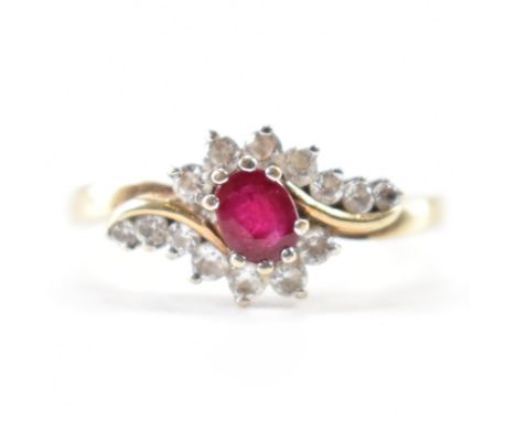 A hallmarked 9ct gold ruby and white stone ring. The ring being set with an oval cut ruby with round cut white accent stones 