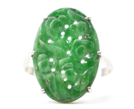 A 1930s Art Deco 9ct white gold and jade panel ring. The ring having a carved oval jade panel to the head. Marked 9ct to the 