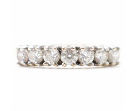 A gold and white stone ring having a row of seven round cut white stones within prong settings to head. Marked 375 &amp; 9K. 