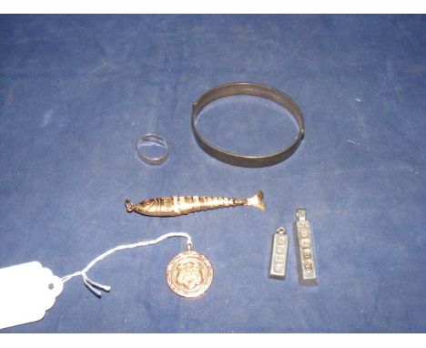 A silver bangle together with two silver ingots, a silver ring, a 9ct. gold medal and a 9ct. gold bracelet charm depicting a 