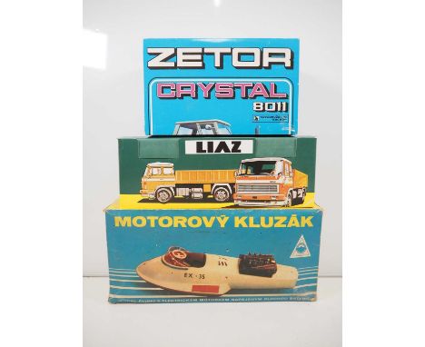 A group of boxed Eastern European battery operated toys comprising a tractor, lorry (both remote control) and a boat - VG in 