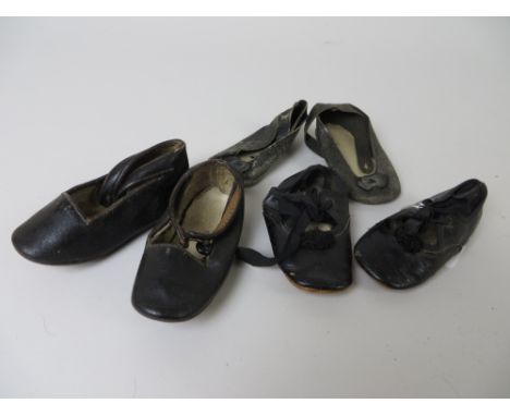 A pair of antique black shoes 5in L, a pair of glacé dolls shoes with pompoms and tie fronts 4 1/4in L and a pair of black 3 