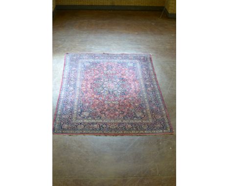 A Persian style Carpet of multi-bordered design with floral designs on a red ground, 14ft x 10ft 5in 