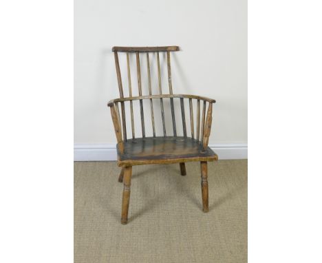 An early 19th Century comb back Windsor Elbow Chair with shaped seat on turned supports and stretchers