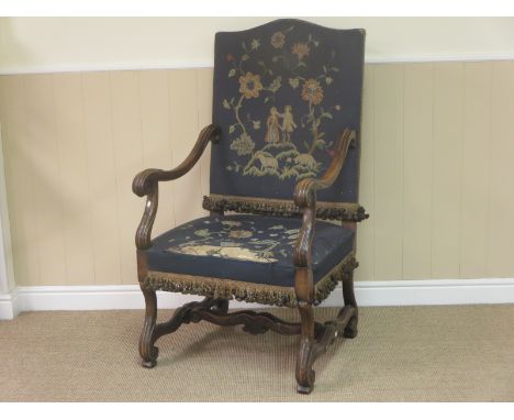 An antique walnut Armchair with tapestry upholstered back and seat, with scroll arms and terminals